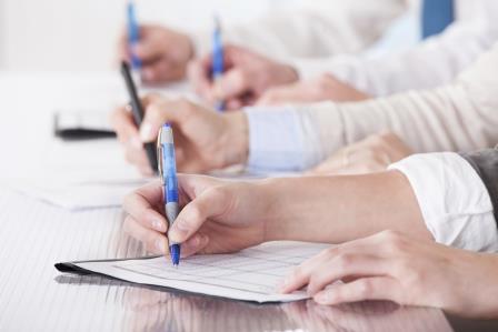 Business People Sitting In A Row And Writing Notes
